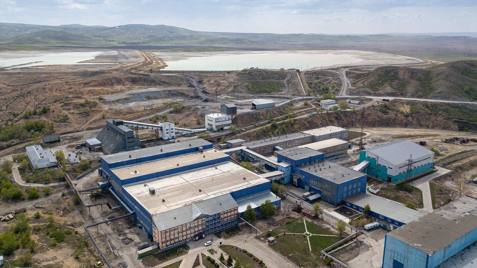 Elevated view of a Bozymchak road leading into a valley full of mountainous landscapes with low hanging cloud.